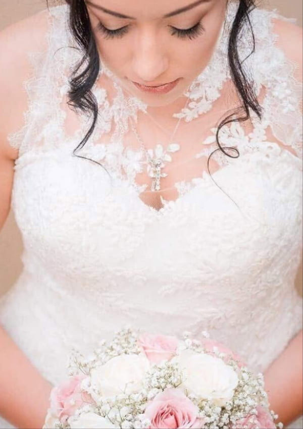 Bride carrying a wedding bouquet by Poppies Florist